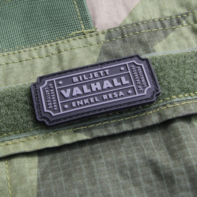 Här syns ett Biljett Valhall PVC Svart/Grå monterat på bröstfickan på en Field Shirt M90.