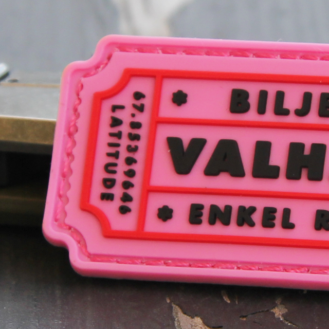 En närbild på ett Biljett Valhall PVC Rosa märke.