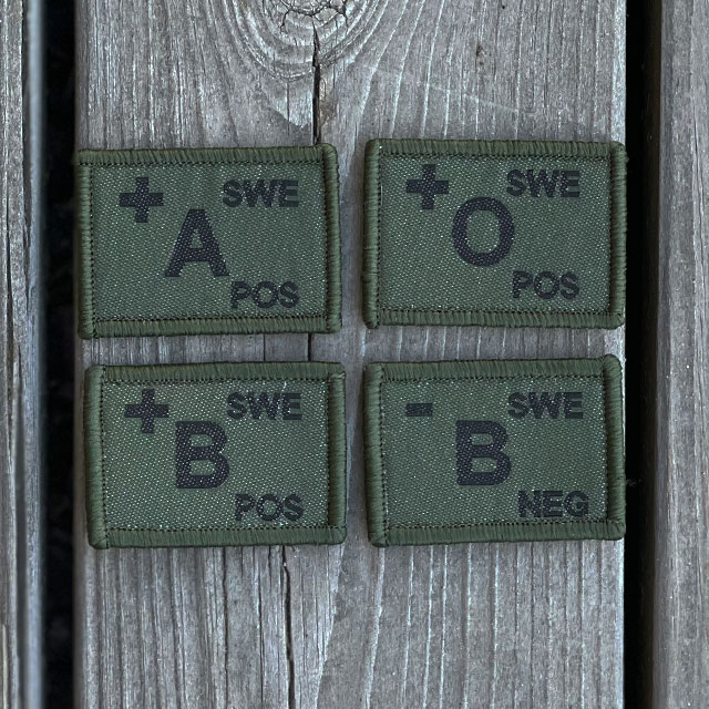 Blood Type Hook Patches Dark Green from TAC-UP GEAR on a wooded floor