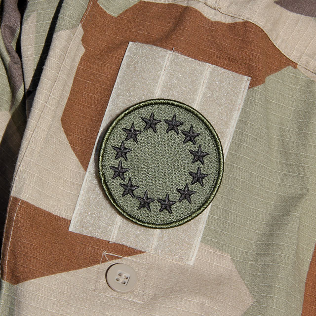 A EU Green Embroidered Patch mounted on a M90K Desert Jacket arm.