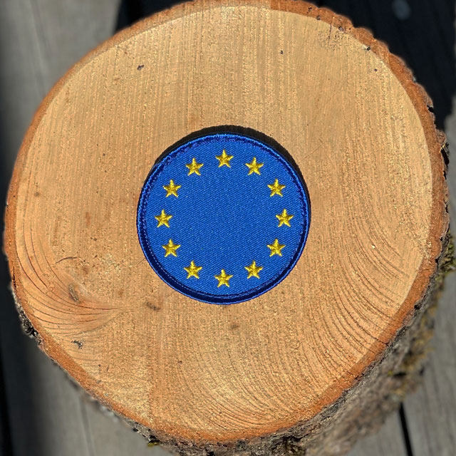 EU Round Blue Hook Patch from TAC-UP GEAR with wooded background