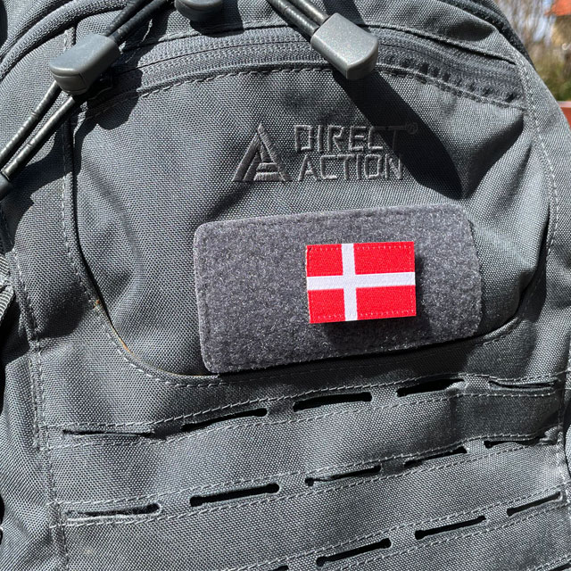 A Denmark Flag Hook Patch Small from TAC-UP GEAR mounted on a grey rucksack seen from an angle