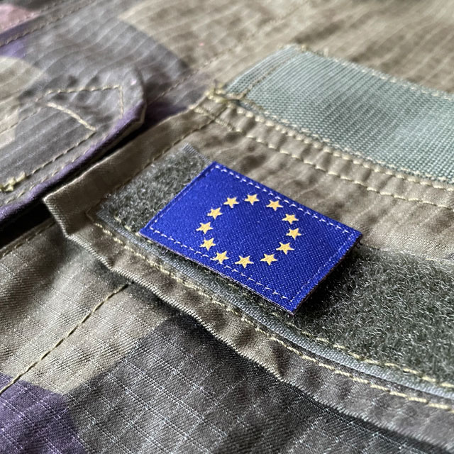 A Blue and yellow EU Flag Hook Patch Small from TAC-UP GEAR on a M90 shirt breast loop