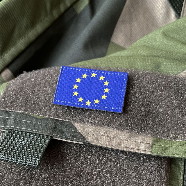 A Blue and yellow EU Flag Hook Patch Small from TAC-UP GEAR on a M90 NCWR Jacket arm pocket