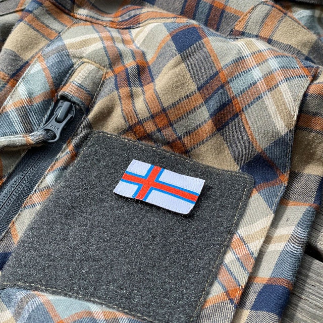 A Faroese Flag Hook Patch Small seen from an angle mounted on a shirt