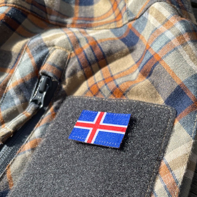 A Iceland Flag Hook Patch Small from TAC-UP GEAR mounted on velcro sleeve on a shirt seen at an angle