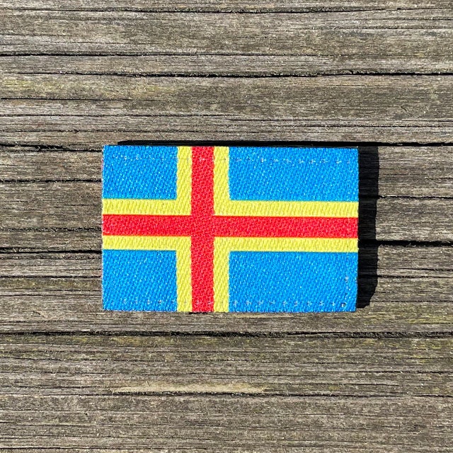 Åland Flag Hook Patch Small from TAC-UP GEAR lying flat on a wooden plank