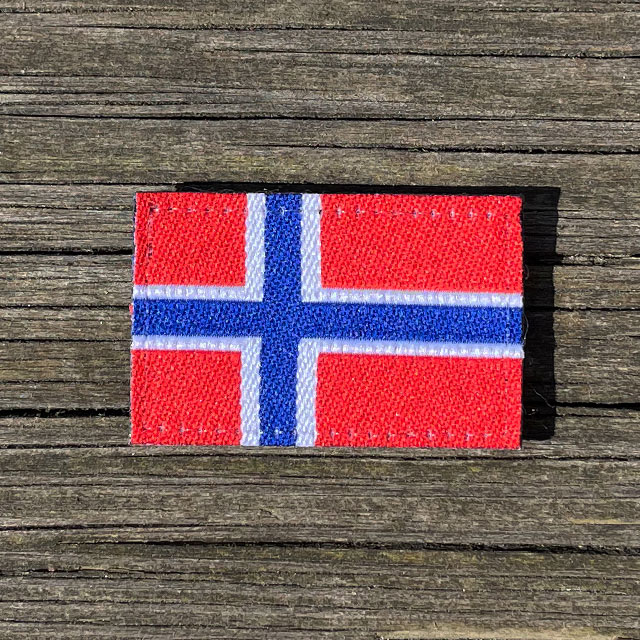 Norway Flag Hook Patch Small from TAC-UP GEAR lying flat on wooded plank