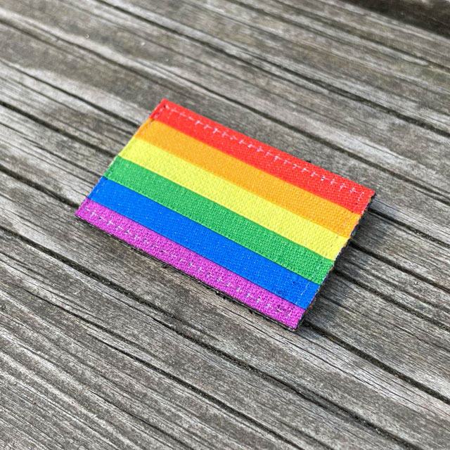 Rainbow Flag Hook Patch Small lying flat on wooded plank seen from an angle