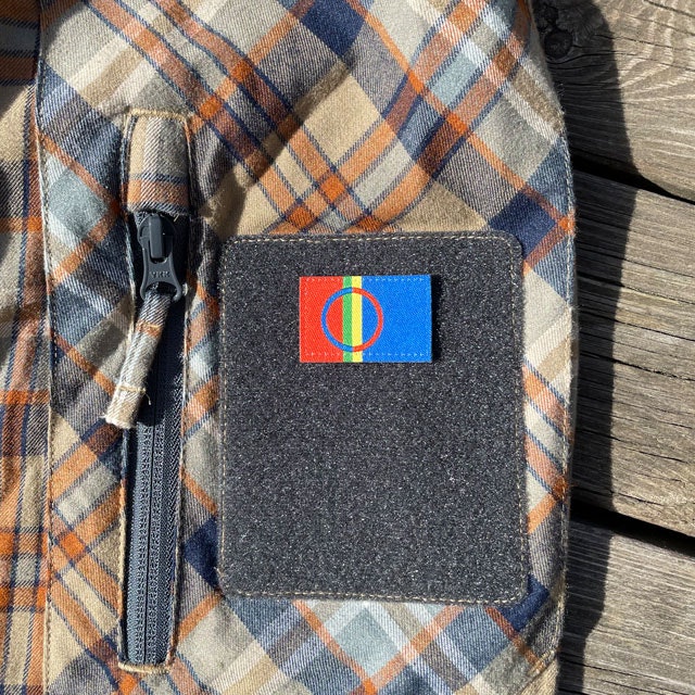 A Sámi Flag Hook Patch Small from TAC-UP GEAR mounted with hook and loop on a shirt sleeve