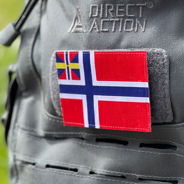 Norges handelsflagga 1844–1898/99 som ett tygmärke med kardborre på baksidan färst på en grå ryggsäck
