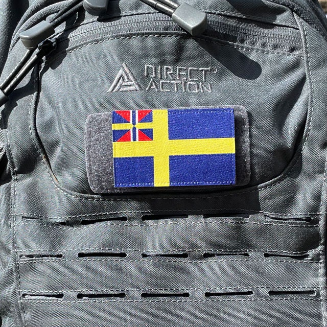 Ett Sveriges handelsflagga 1844–1905 från TAC-UP GEAR monterat på en grå ryggsäck sedd från sidan
