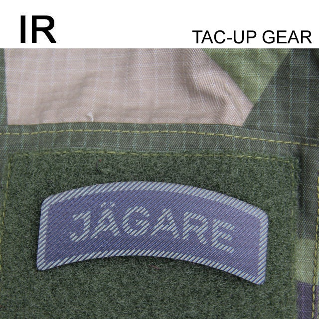 A IR - JÄGARE Dual Grön/Svart mounted on a M90 camouflage jacket.