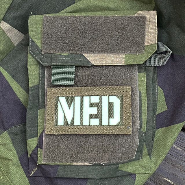 A IR - MED Black-Green Reversible Glow Hook Patch mounted on a M90 sleeve green side out