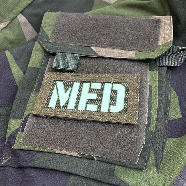 A IR - MED Black-Green Reversible Glow Hook Patch mounted on a M90 sleeve green side out seen from the side