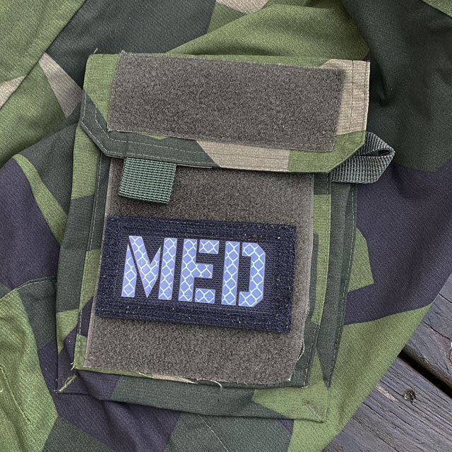 A IR - MED Black-Green Reversible Glow Hook Patch mounted on a M90 sleeve black side out