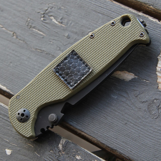 The smallest patch included in the IR Tactical Glint Square x 6 Bundle on a knife for size comparison.