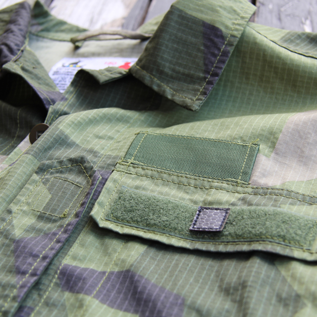 The IR Tactical Glint Square - 2 cm seen mounted on the pocket lid of a Field Shirt M90.