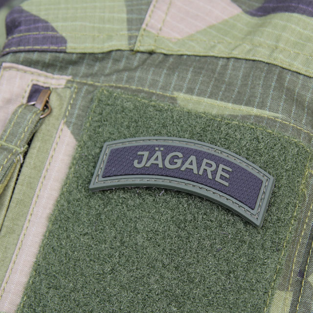 A mounted JÄGARE Green/Black PVC Patch M15 on the arm of a Field Shirt M90.