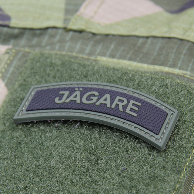 A mounted JÄGARE Green/Black PVC Patch M15 on the arm of a Field Shirt M90.