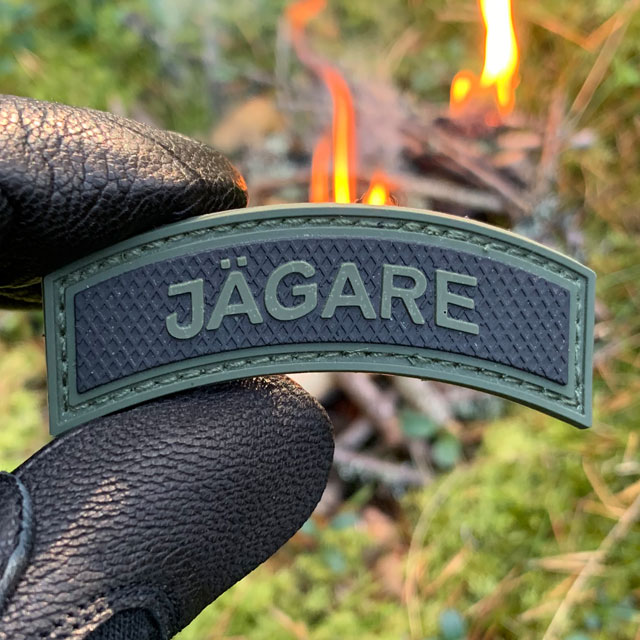 JÄGARE Green/Black PVC Patch M15 at the camp site in the Swedish forest.