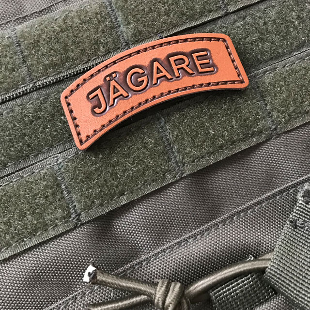 The JÄGARE Leather Hook Patch Tab mounted on a ranger green plate carrier.