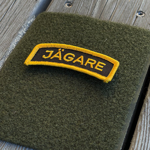 A JÄGARE Hook Patch Orange/Black seen from an angle mounted on a hook piece