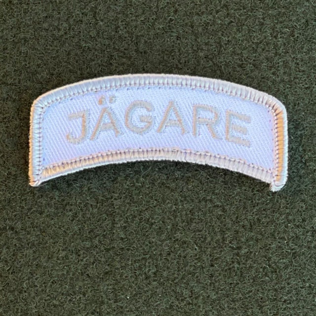 A JÄGARE Hook Patch Silver Grey/White from TAC-UP GEAR on green loop fabric