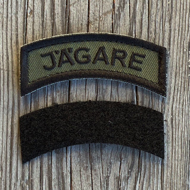 A JÄGARE K3 Type Hook Patch Black/Green seen from the front with its loose black loop piece