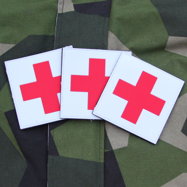 The Medic Cross PVC Hook Patch x 3 Bundle with M90 camouflage background.