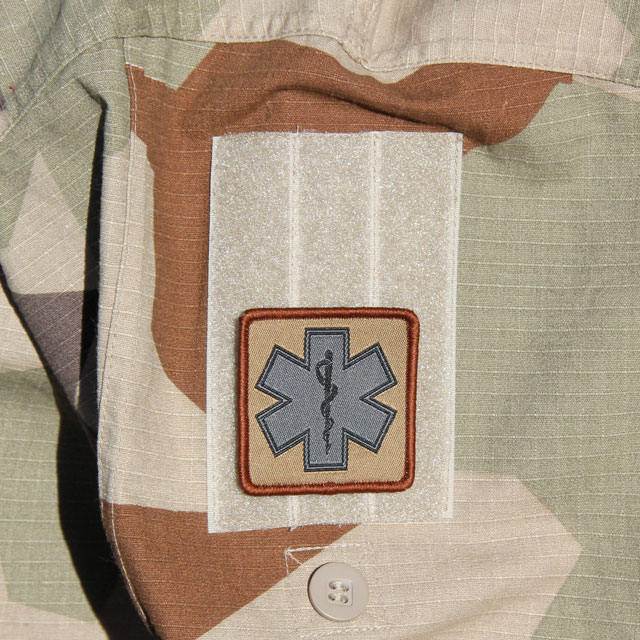 Mounted MEDIC Desert Star Hook Patch on the arm of a M90K Desert camouflage jacket.