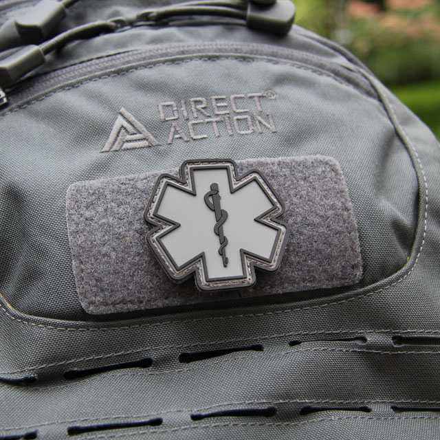 A MEDIC PVC Star Black Grey Hook Patch mounted on a rucksack.