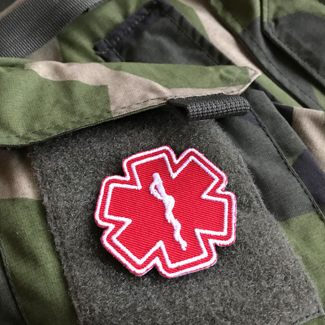 M90 camouflage jacket and a MEDIC Star of Life Red White Hook Patch.