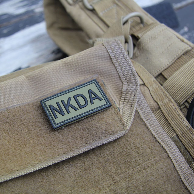 A NKDA Green/Black PVC Hook Patch mounted on a combat vest.