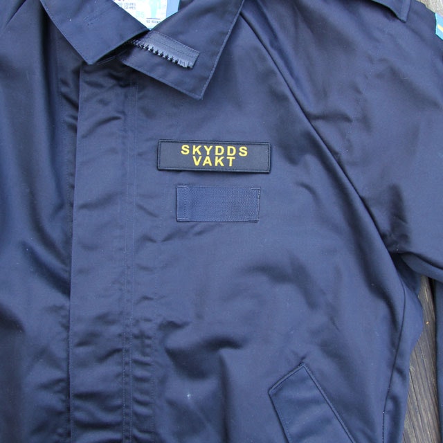 Marinens blåa uniformsjacka och ett Skyddsvakt Avlång Kardborremärke.
