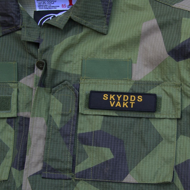 Ett Skyddsvakt Avlång Kardborremärke på en M90 uniform.