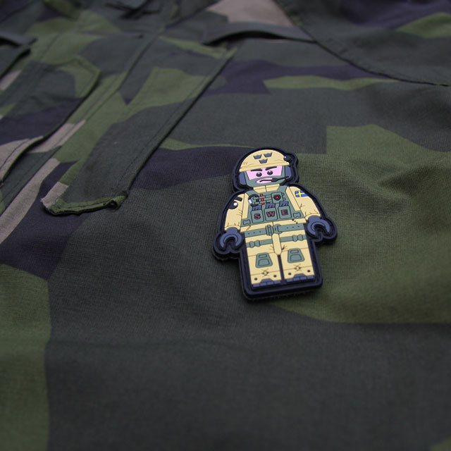 A SWE SOG PVC Figur Patch on M90 camouflage background.