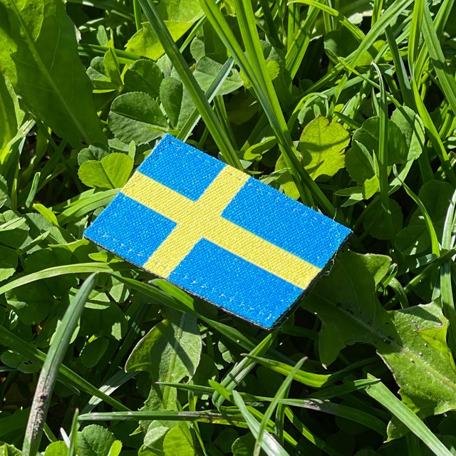 A Sweden Flag Hook Patch Arm with grass background