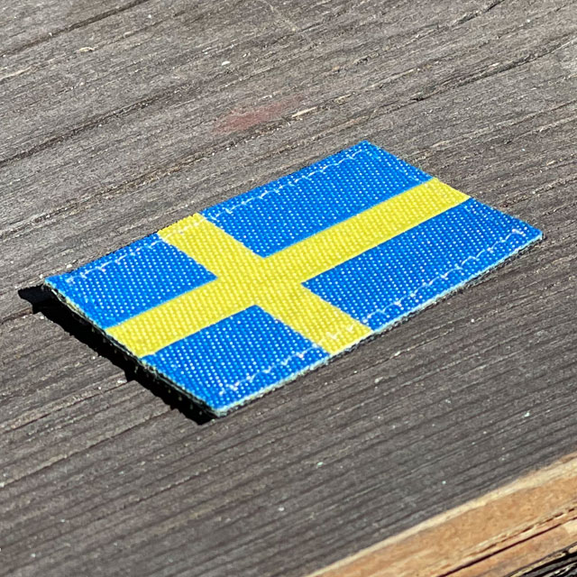 A Sweden Flag Hook Patch Arm on wooded floor background