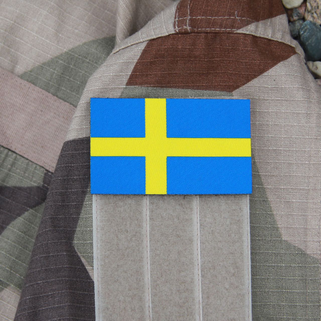 A Sweden Flag Large Hook Patch mounted on the arm of a M90K Desert jacket sleeve.