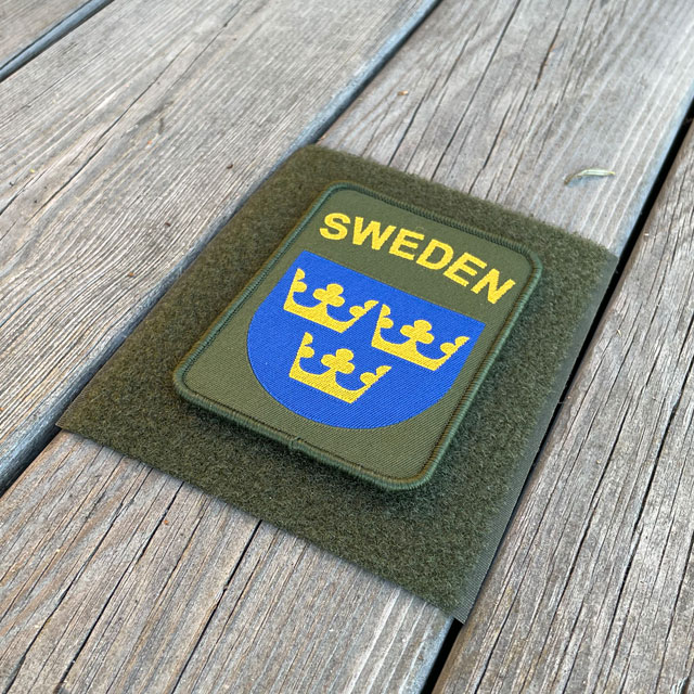 A Sweden Hook Patch Green from TAC-UP GEAR on green loop fabric on wooded floor