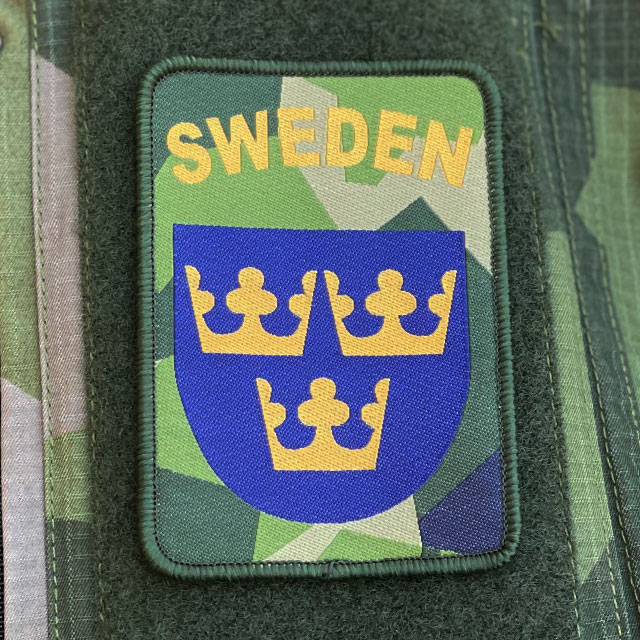 Sweden Hook Patch M90 from TAC-UP GEAR mounted on a M90 camouflage Shirt