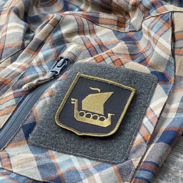 Viking Ship Shield Large Olive and Black Hook Patch seen from an angle mounted on an arm on a shirt