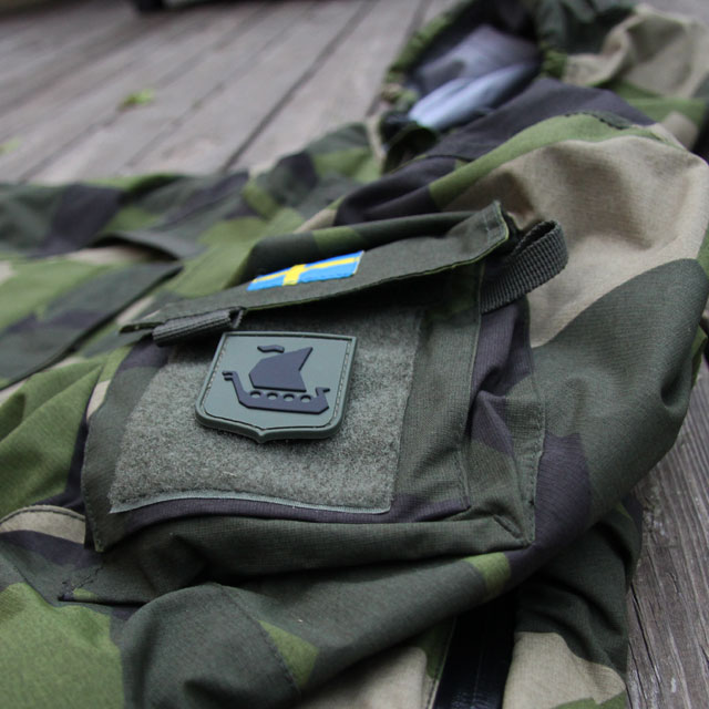 M90 kamouflage jacka och ett Vikingship Shield Hook PVC Green/Black Patch märke.