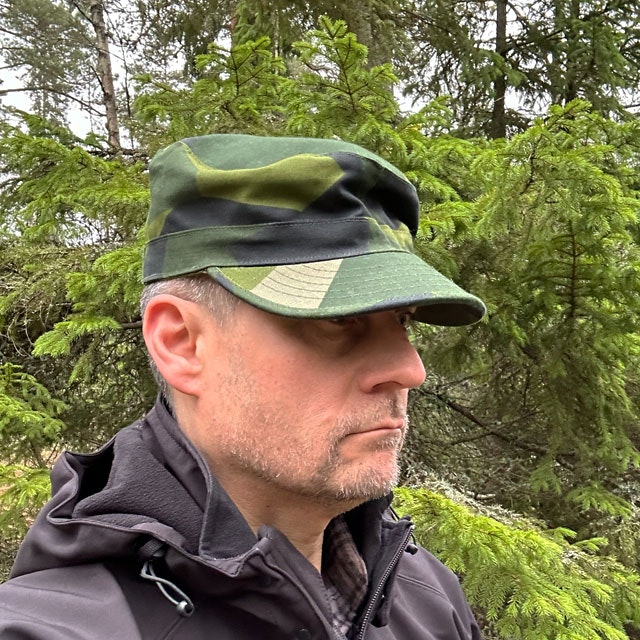 Patrol Cap M90 from TAC-UP GEAR on a model in the Swedish forest wearing a black jacket