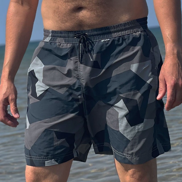 POSEIDON Swim Shorts M90 Grey seen from the front on model with ocean as background