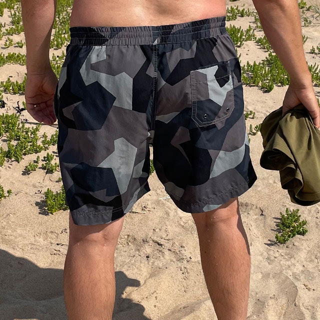 POSEIDON Swim Shorts M90 Grey from TAC-UP GEAR on model seen from the back on the beach in the sun