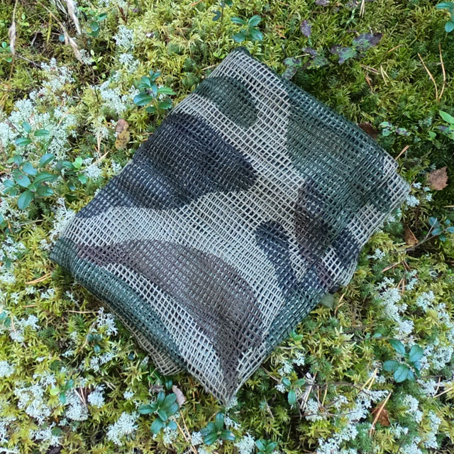 A folded Scrim Net Scarf FR Commando on the Swedish forest floor
