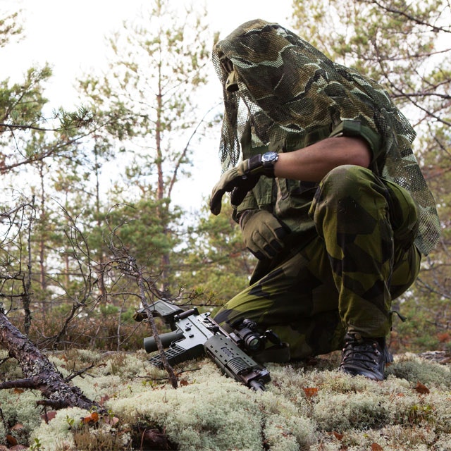 The Scrim Scarf M90 is draped over a Boonie Hat M90 and used as camouflage.