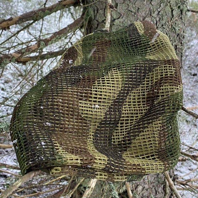 a Scrim Net Scarf Woodland on branches of a tree
